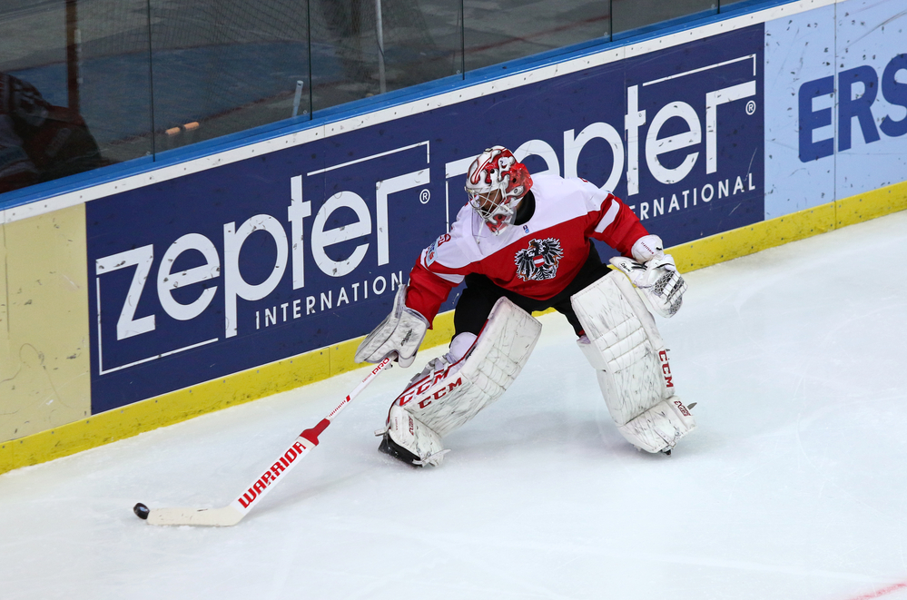 Goalie playing the puck along the boards